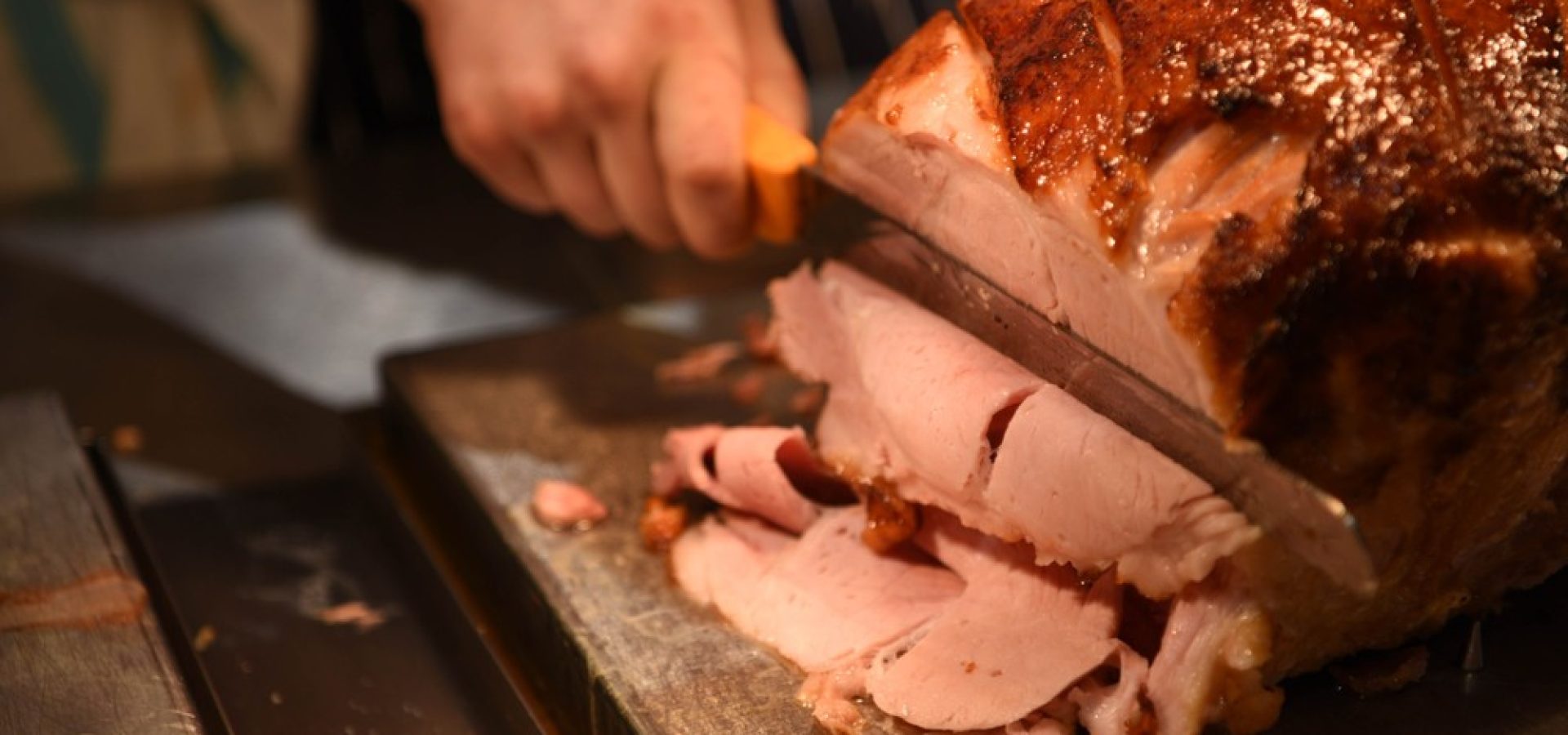 Wibest – Pigs: A chef slicing a cooked ham.