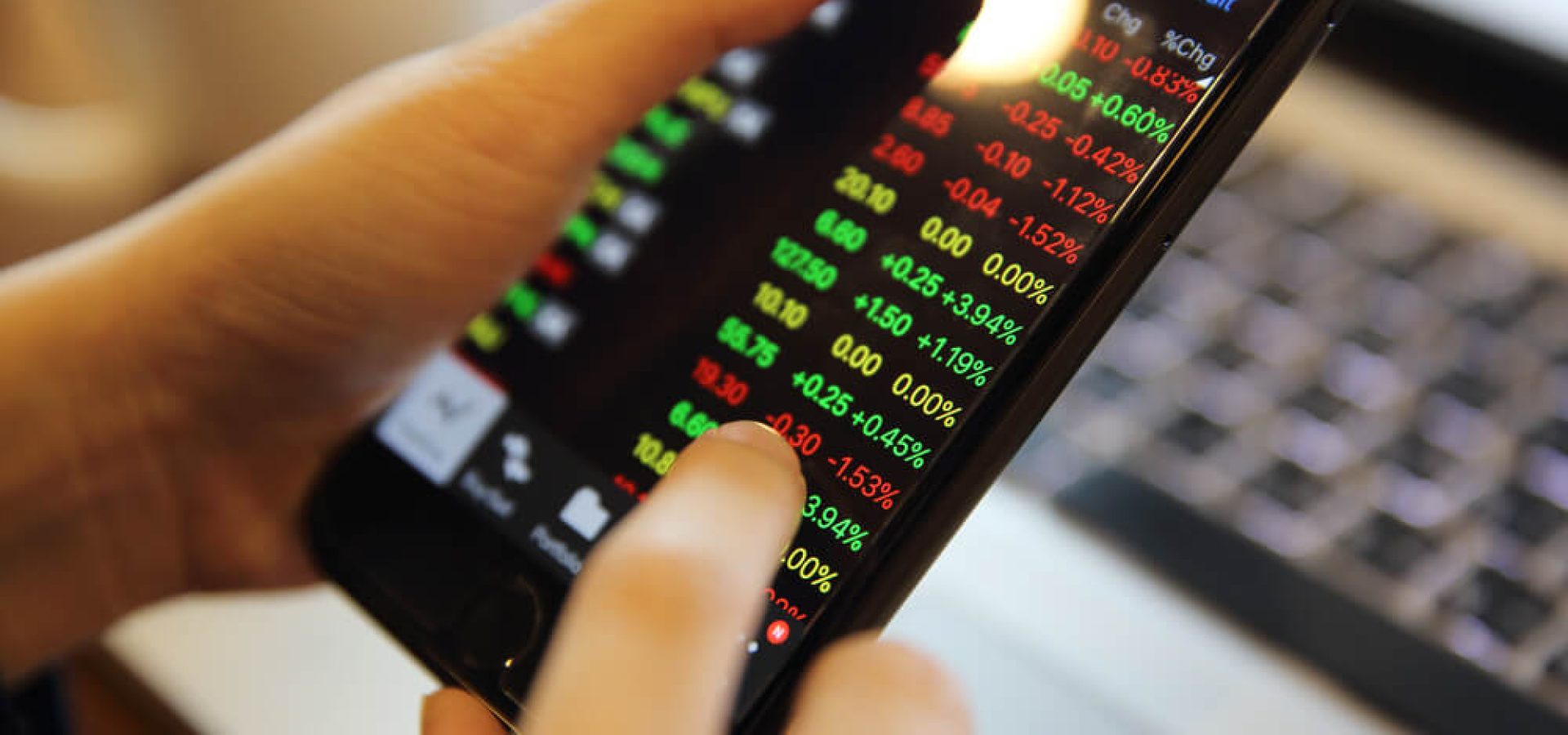a finger checking out stocks on a tablet phone